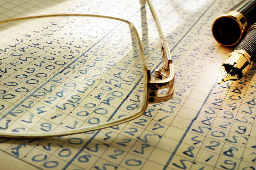 Hand written ledger with glasses and pen.